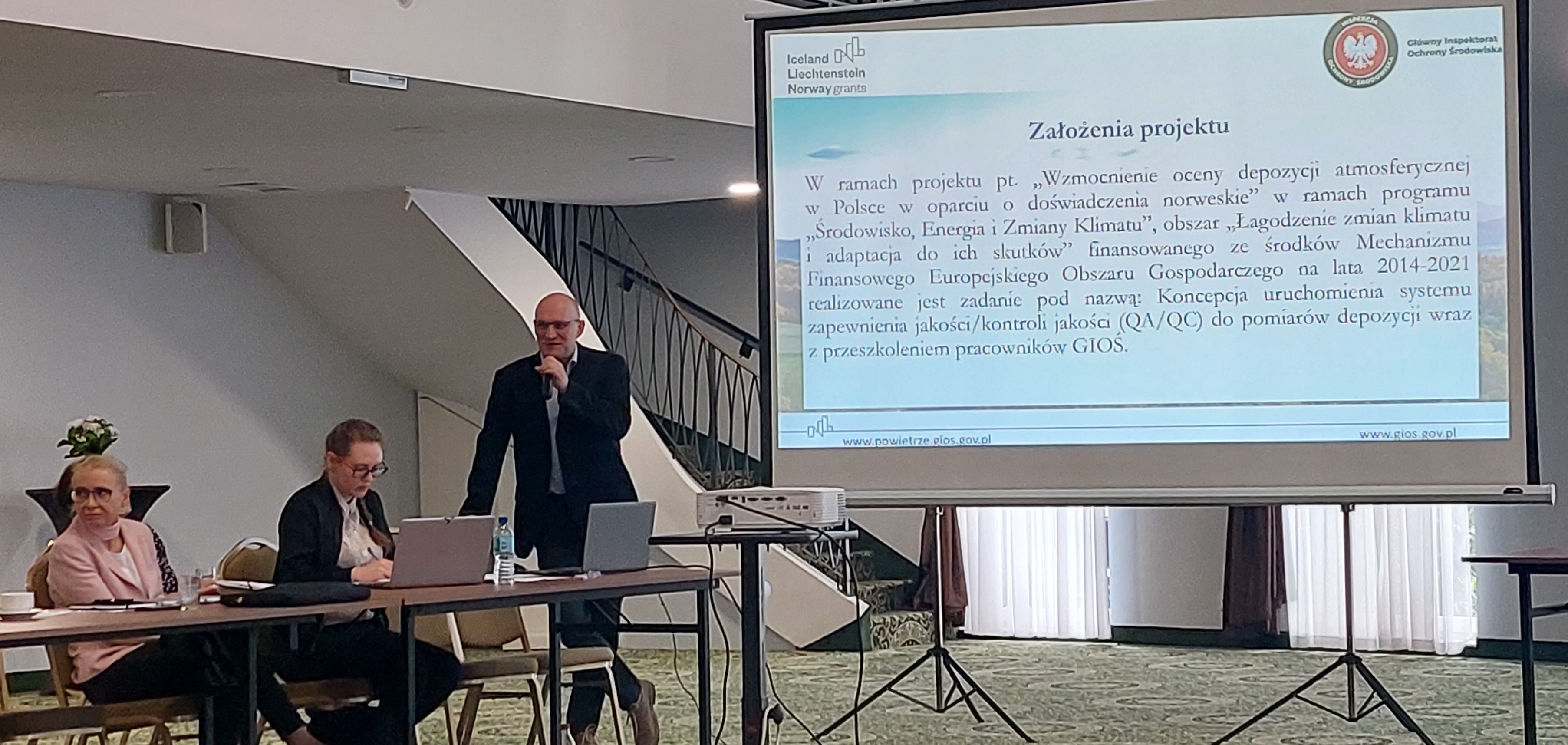 Tomasz Frączkowski, Kierownik Krajowego Laboratorium Wzorcującego do spraw jakości powietrza atmosferycznego, na tle swojej prezentacji